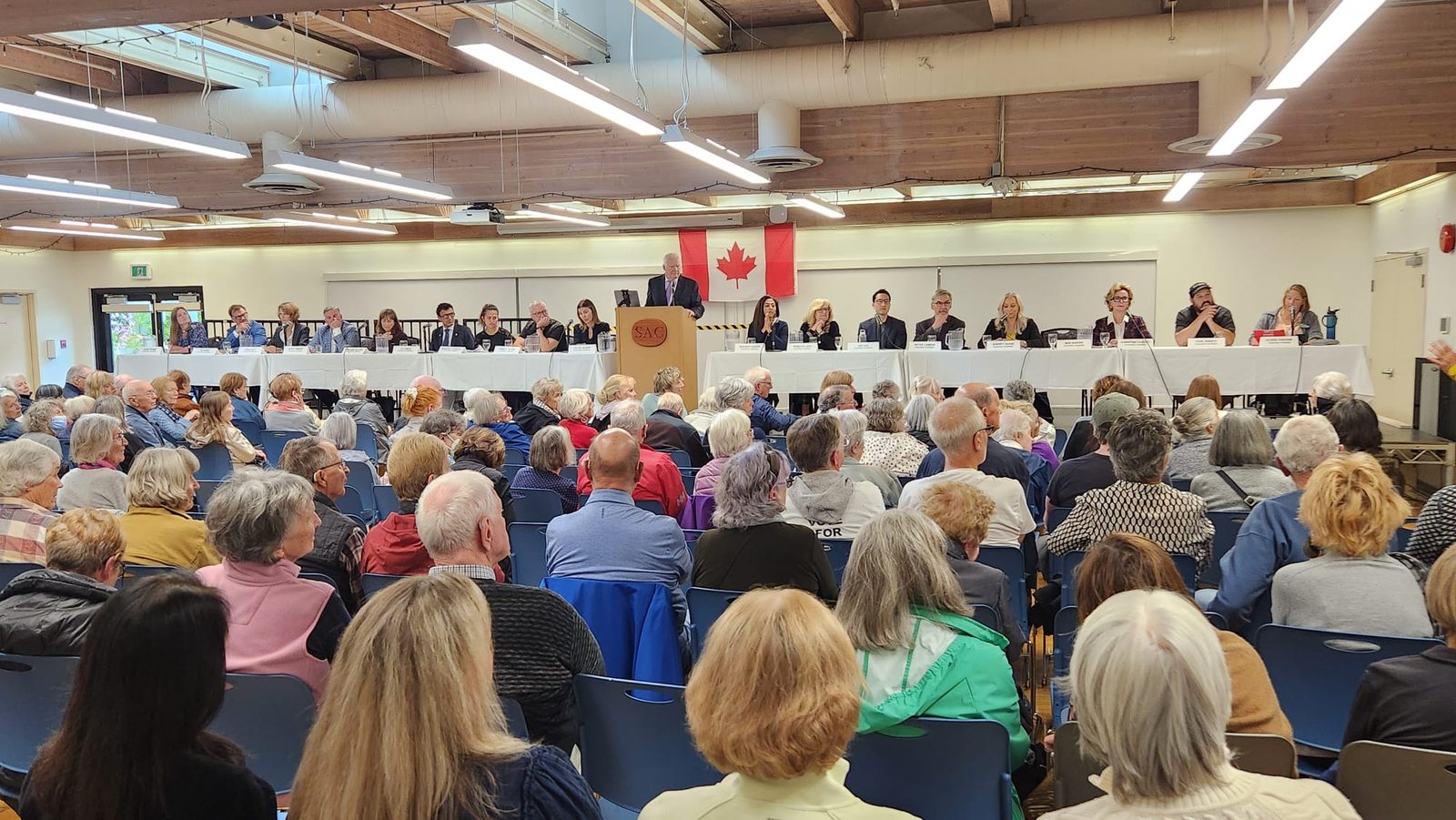 A large audience facing a full panel of candidates at the all-candidates meeting in the Seniors' Centre Activity Room