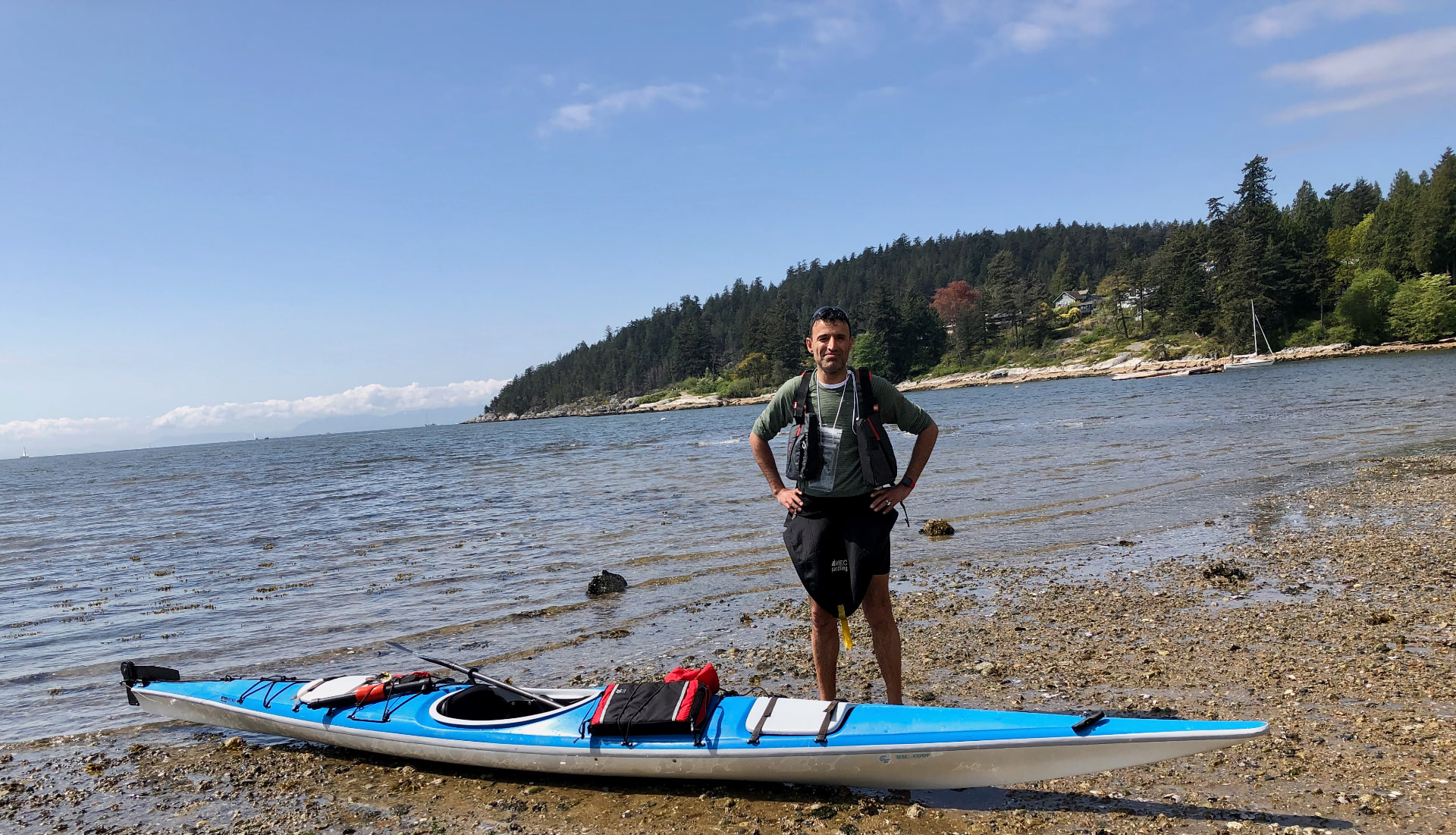 Jay Sidhu with a sea kayak on a West Vancouver beach