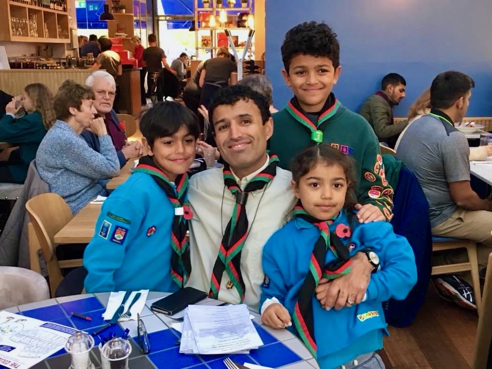Jay Sidhu in Scout uniform with three young Scouts