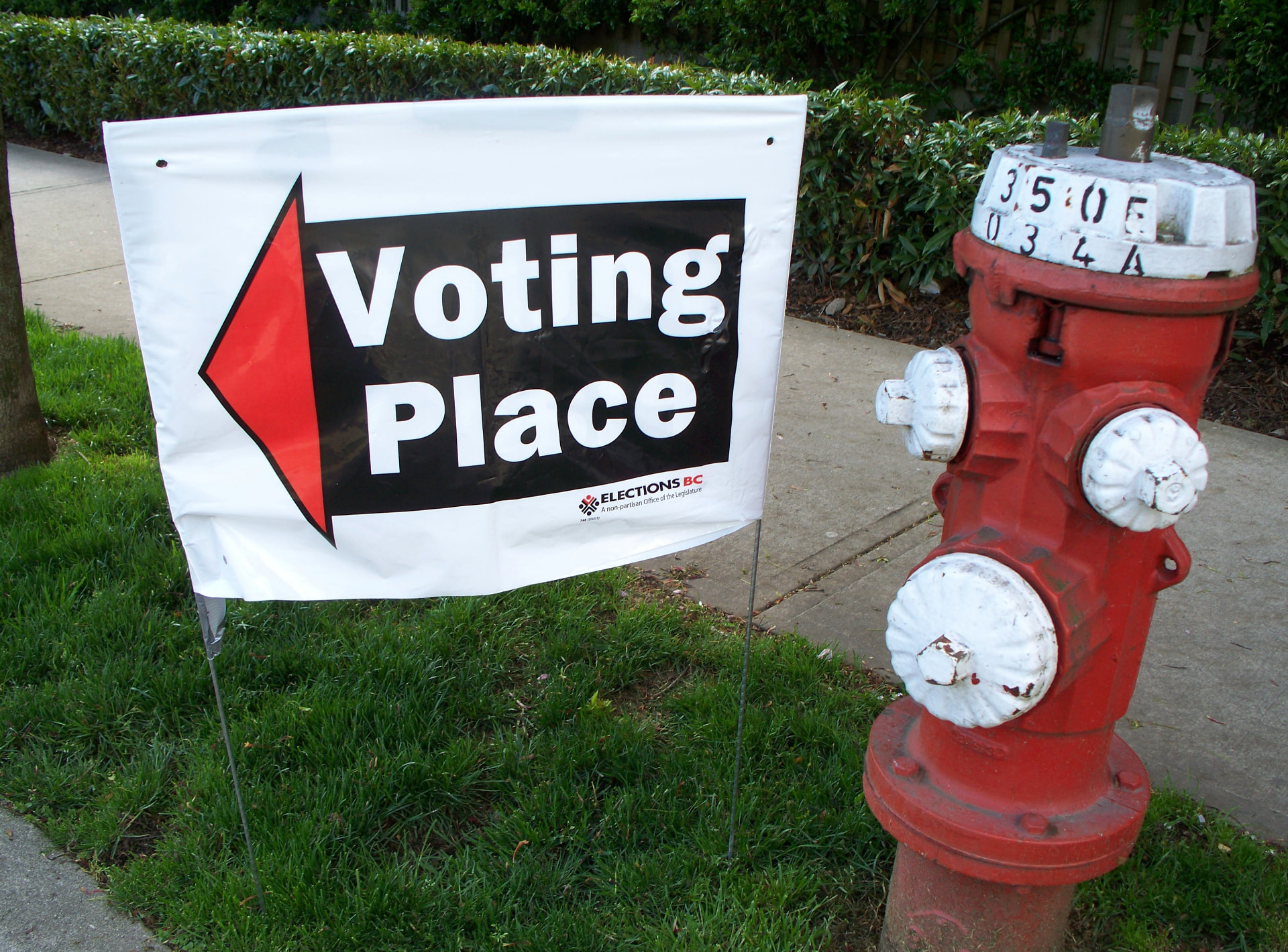 A 'Voting Place' sign positioned next to a fire hydrant. Taken by Dennis Sylvester Hurd from New Westminster, BC, Canada. Creative Commons.